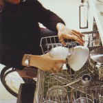 Kerekesszékben ülő hölgy kipakol a mosogatógépből