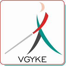A képen egy szinesbaba (piros. zöld, fekete) fehér bottal és VGYKE felirat látható