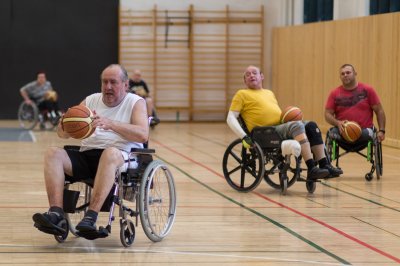 A képen kerekesszékes férfiak láthatók kosárlabdázás közben.