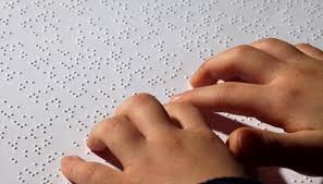 A képen két kéz látható Braille olvasás közben.