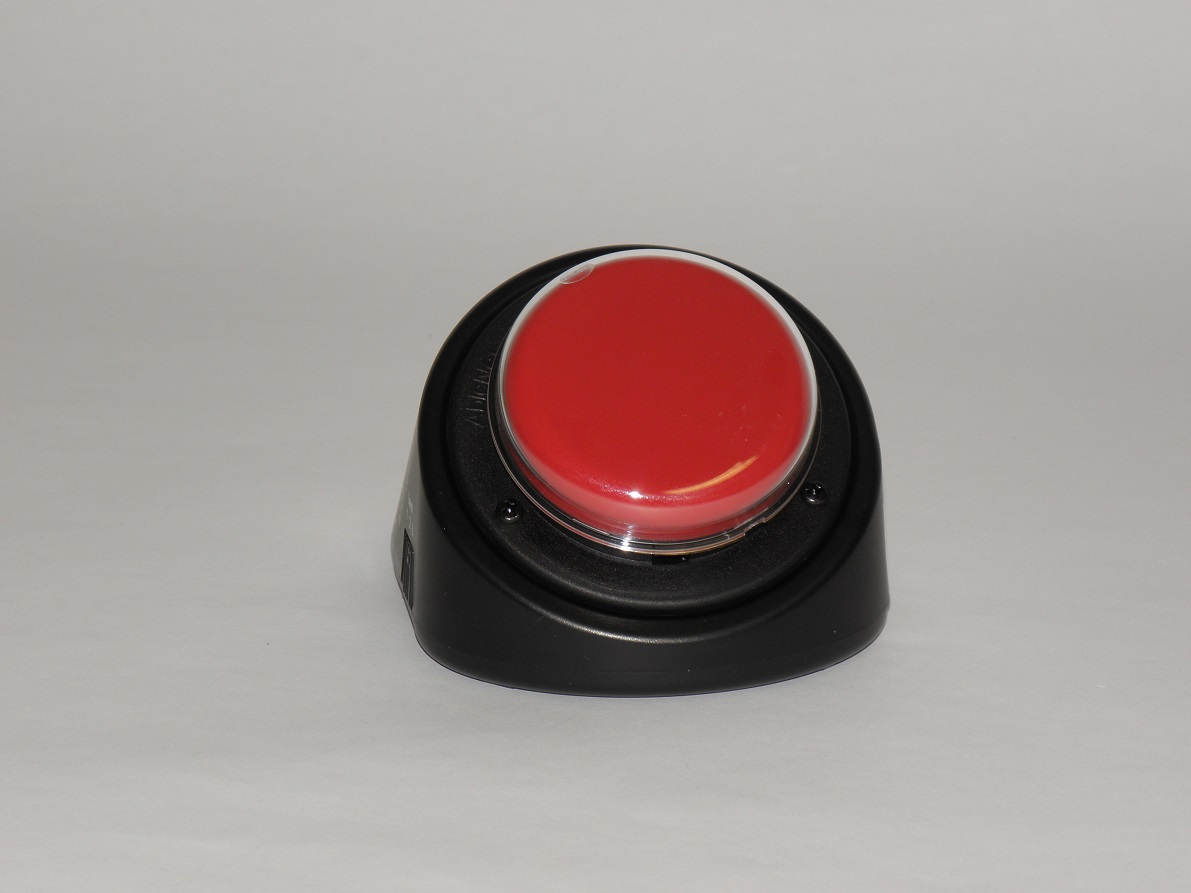 Döntött piros gombbal ellátott kommunikátor látható a képen.